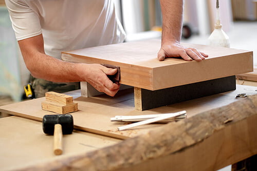 sanding a piece of wood - LSK Building Westbury, Warminster and Trowbridge